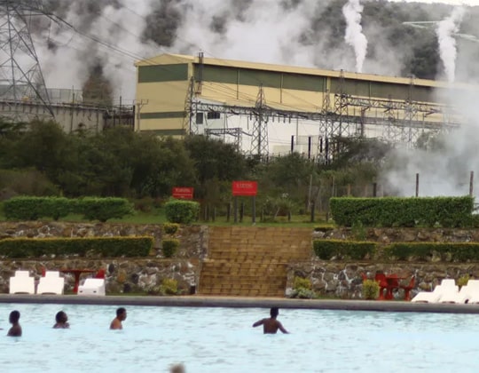 People relax in a geothermal pool at a commercial spa located next to the Olkaria geothermal power plant in Kenya, illustrating the direct use of geothermal heat alongside electricity generation.